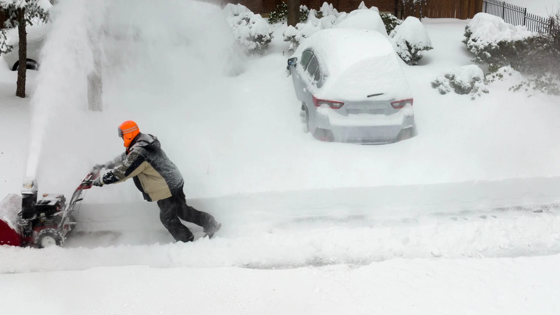 Snowblower clearing a residential driveway after fresh snow